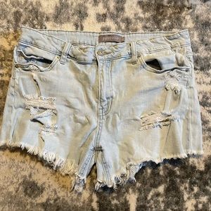 Slightly worn Jean shorts, light blue stretchy material.